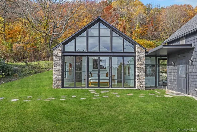 a view of a house next to a big yard and large trees