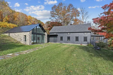 a view of a yard in front of a house with a large tree
