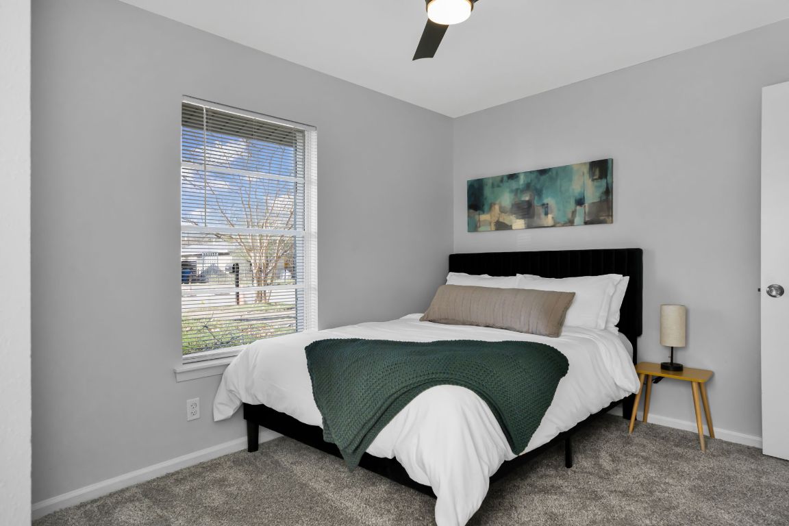 1205 Arthur Stiles Road Austin, TX 78721 - Photo 16 of 20 a bedroom with a bed lamp and a window