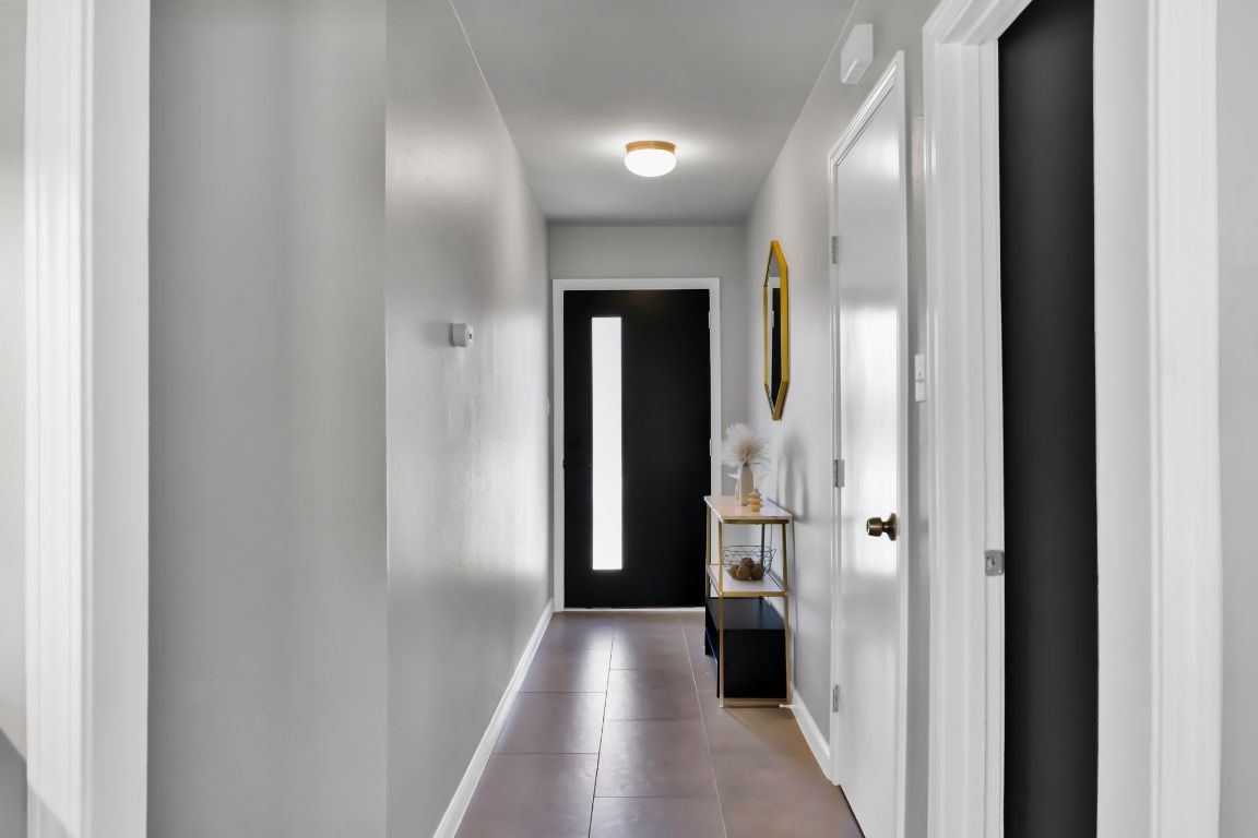 1205 Arthur Stiles Road Austin, TX 78721 - Photo 3 of 20 a view of a hallway with wooden floor and a bathroom