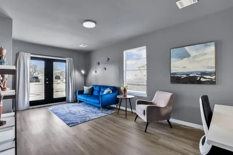 a living room with furniture rug and wooden floor