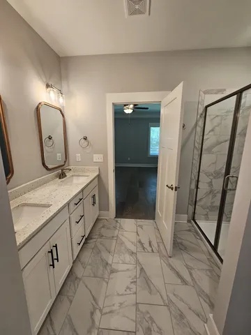 a spacious bathroom with a double vanity sink and a mirror