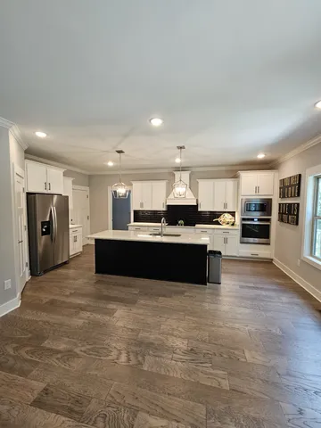 a large kitchen with kitchen island granite countertop a refrigerator and a sink