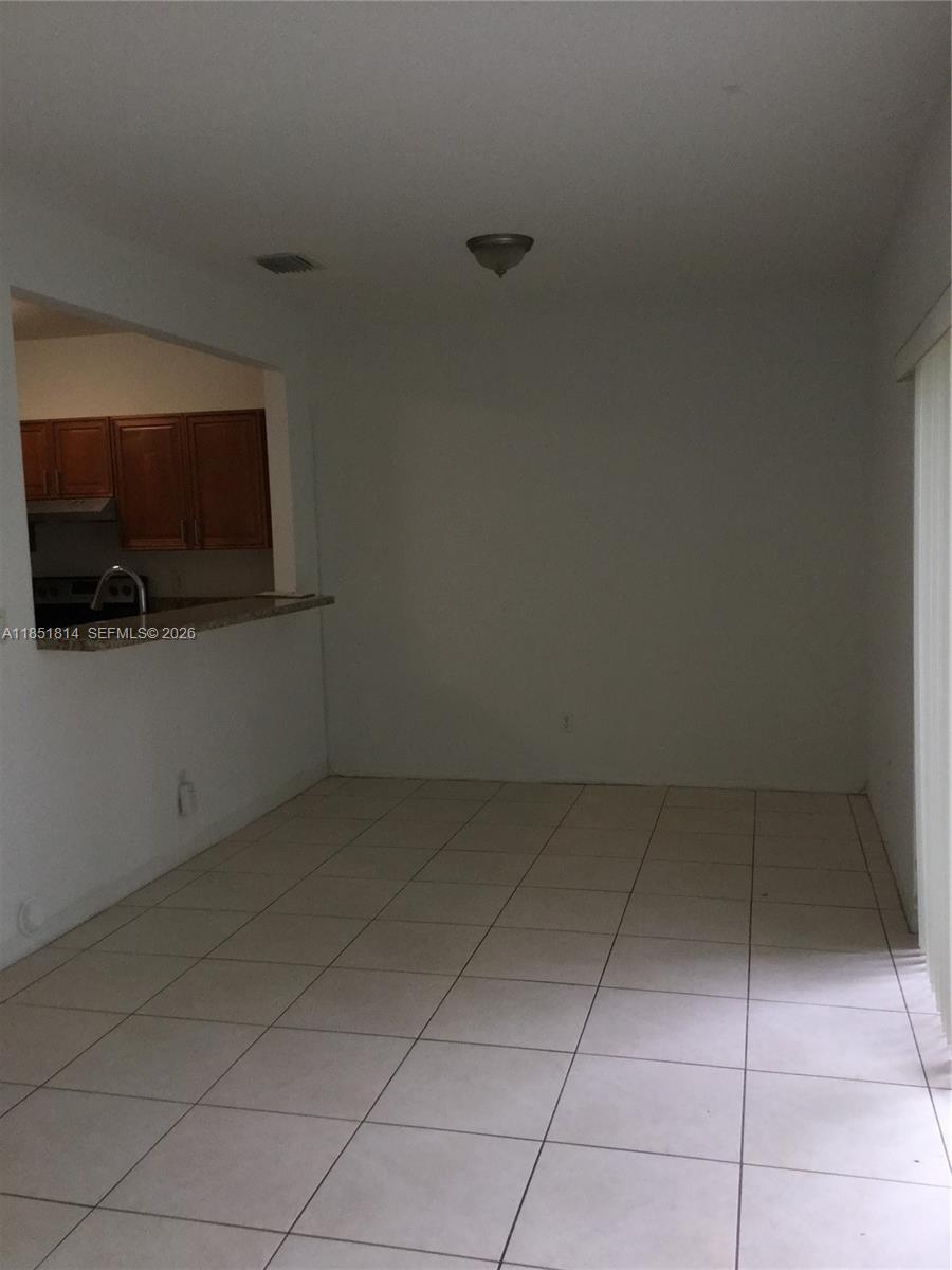 2885 Southwest 127th Avenue Miramar, FL 33027 - Photo 4 of 13 a room with a flat screen tv and kitchen view