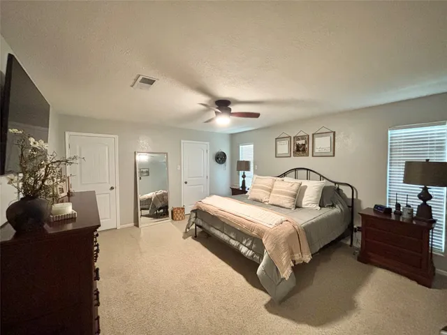 a spacious bedroom with a bed and a flat screen tv