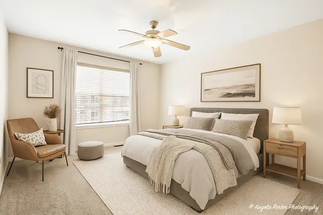 a spacious bedroom with a bed and a chair