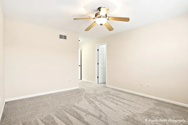 a view of a room with a ceiling fan and a window