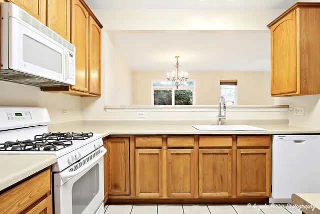 a kitchen with granite countertop a sink a stove and cabinets