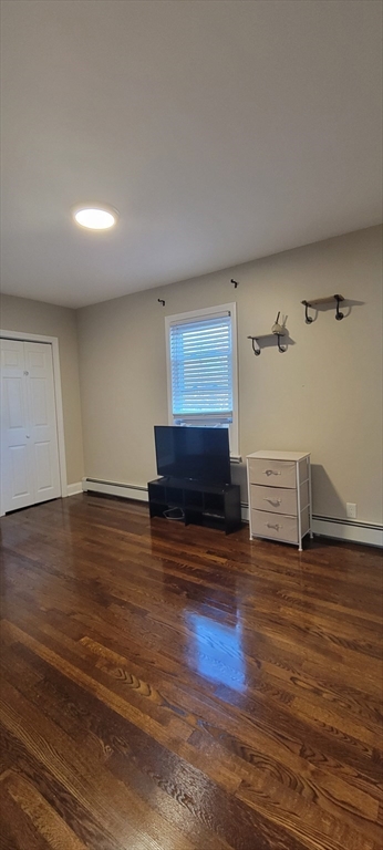 11 Walter Street, Unit 2 Boston, MA 02136 - Photo 20 of 26 a view of an empty room with wooden floor and a fireplace