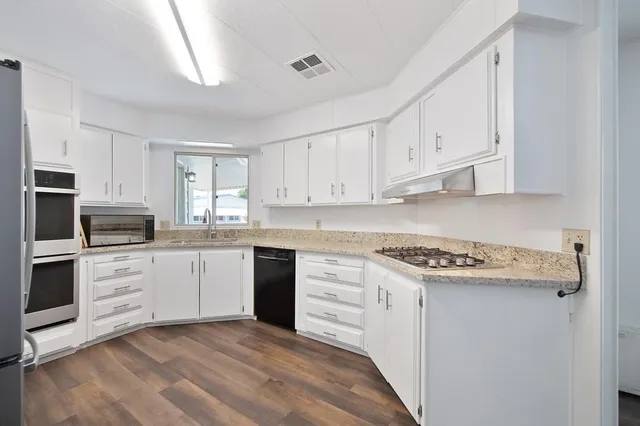 a kitchen with white cabinets and appliances