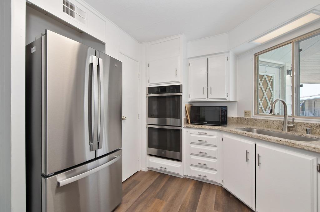 163 Rimma Way Roseville, CA 95661 - Photo 12 of 35 a kitchen with white cabinets and stainless steel appliances