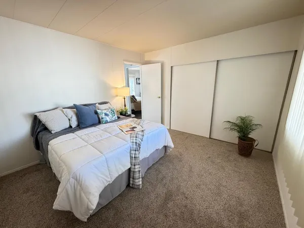 a bedroom with a bed and a potted plant
