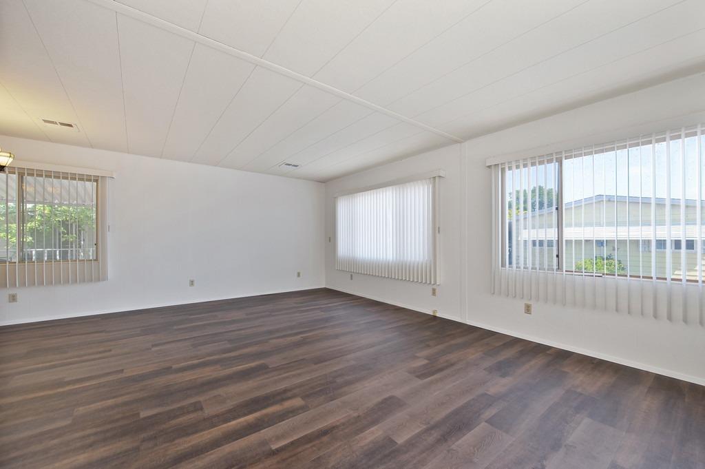 163 Rimma Way Roseville, CA 95661 - Photo 6 of 35 an empty room with wooden floor and windows