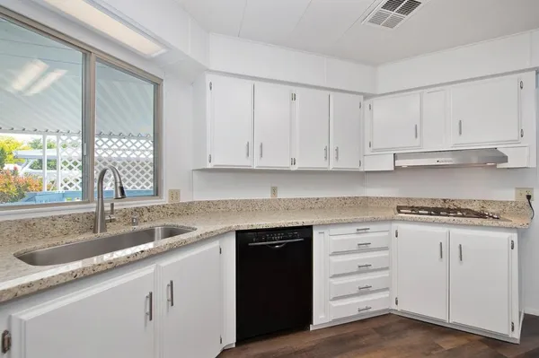 a kitchen with granite countertop a sink and cabinets