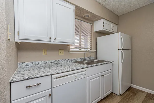a kitchen with granite countertop cabinets and refrigerator