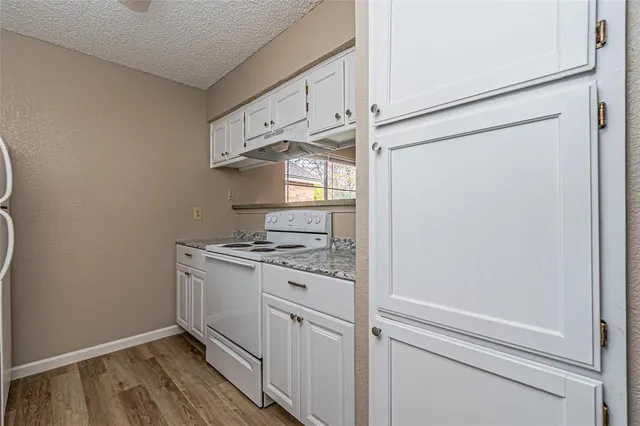 a kitchen with white cabinets and white appliances