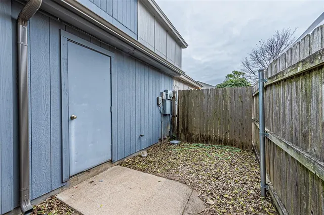 a view of a house with a small yard and wooden fence