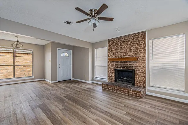 an empty room with windows and a fireplace