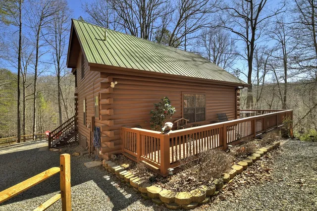 a view of a brick house with a small yard and wooden fence