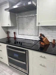 a kitchen with a stove and white cabinets