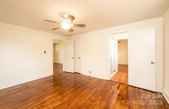 a view of empty room with wooden floor