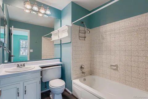 a bathroom with a bathtub sink vanity mirror and toilet