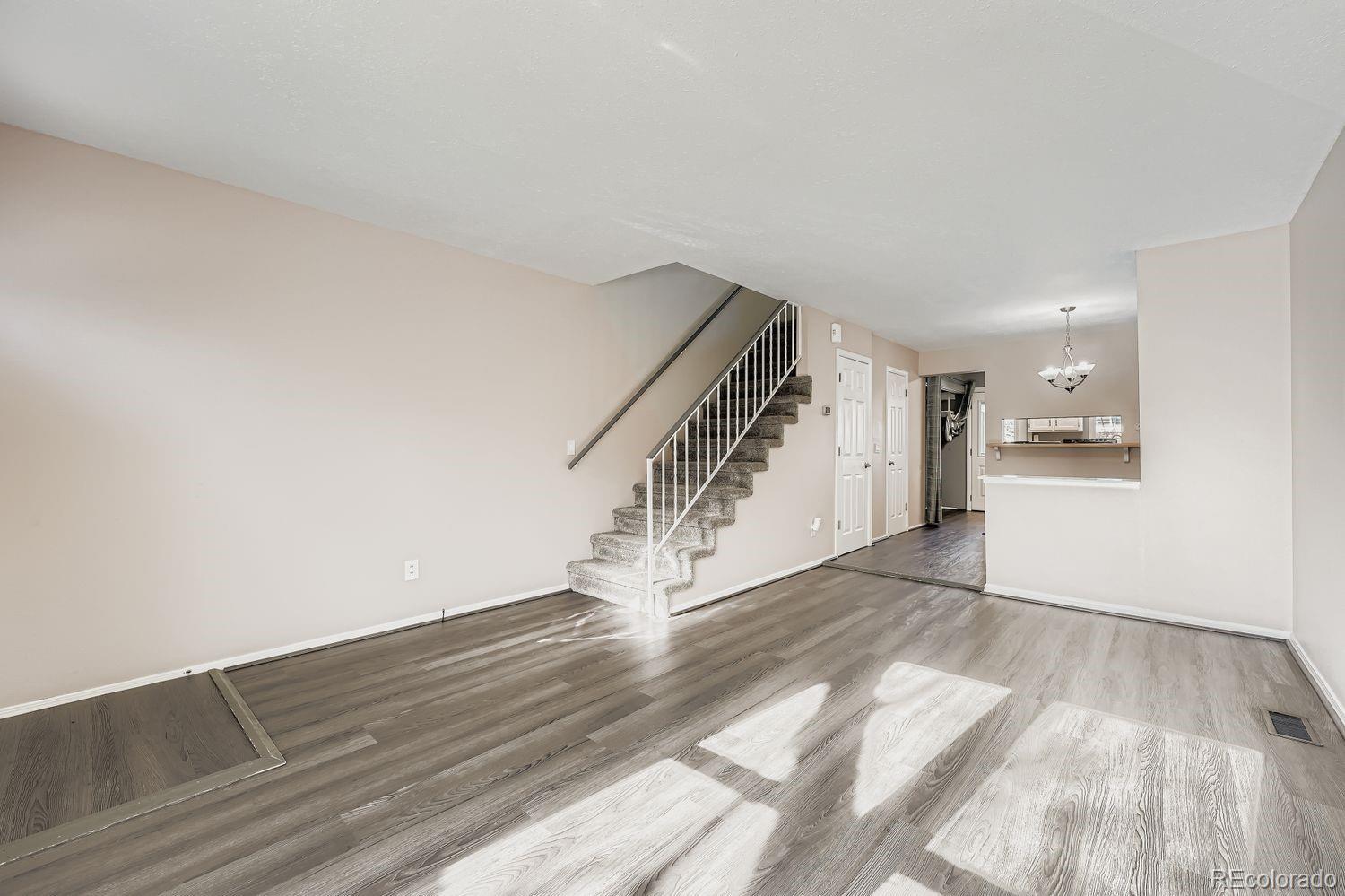 2204 South Jasper Way, Unit B Aurora, CO 80013 - Photo 3 of 19 a view of an empty room and wooden floor
