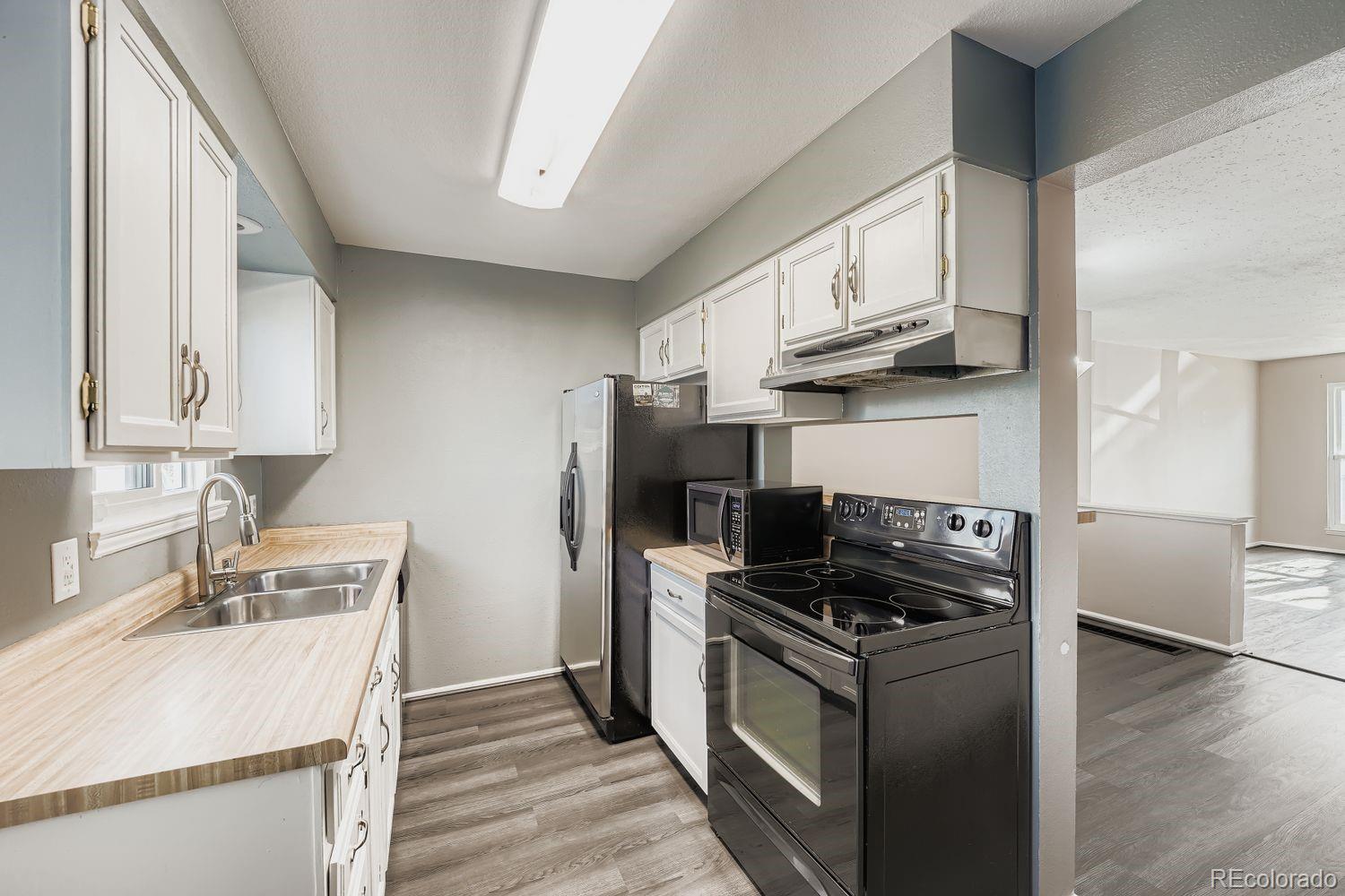 2204 South Jasper Way, Unit B Aurora, CO 80013 - Photo 5 of 19 a kitchen with stainless steel appliances granite countertop a sink stove and refrigerator