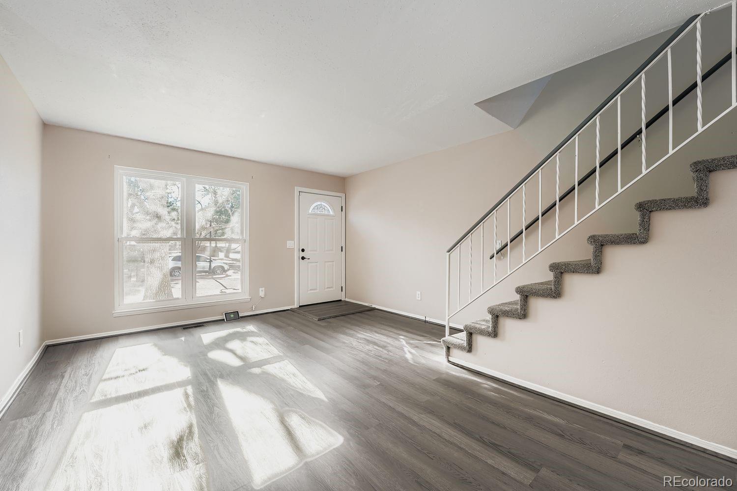 2204 South Jasper Way, Unit B Aurora, CO 80013 - Photo 8 of 19 a view of an empty room with wooden floor and a window