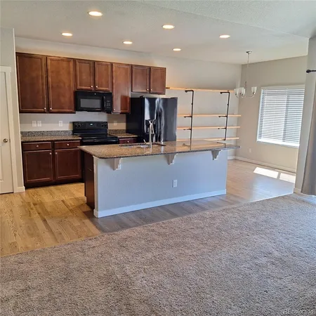 a kitchen with stainless steel appliances granite countertop a refrigerator stove microwave and sink