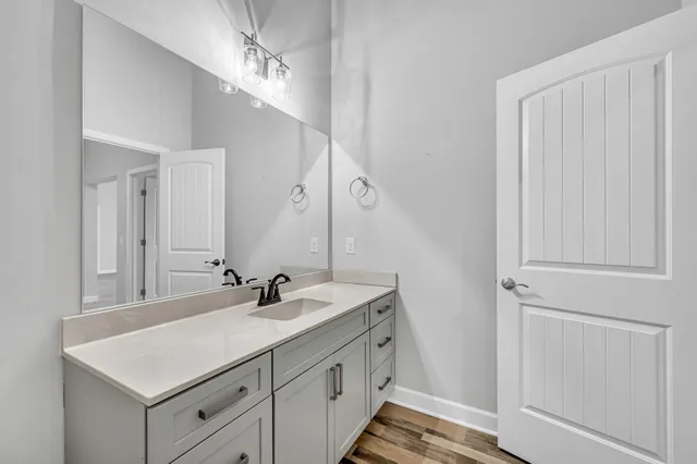 a bathroom with a toilet a sink a mirror a lamp and vanity