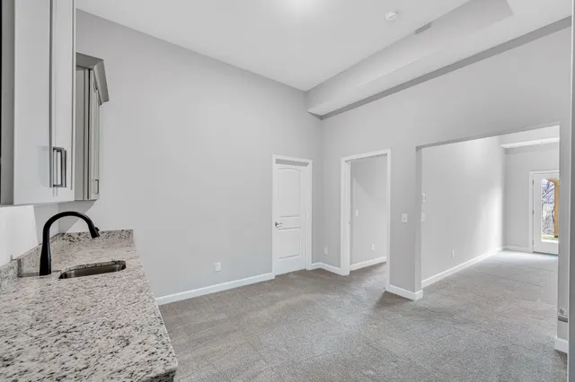 a large white room with a sink and dishwasher