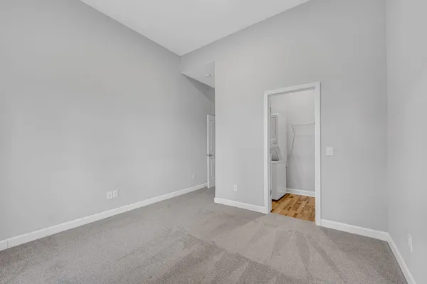 a view of an empty room with closet and a window
