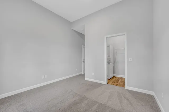 a view of an empty room with closet and a window