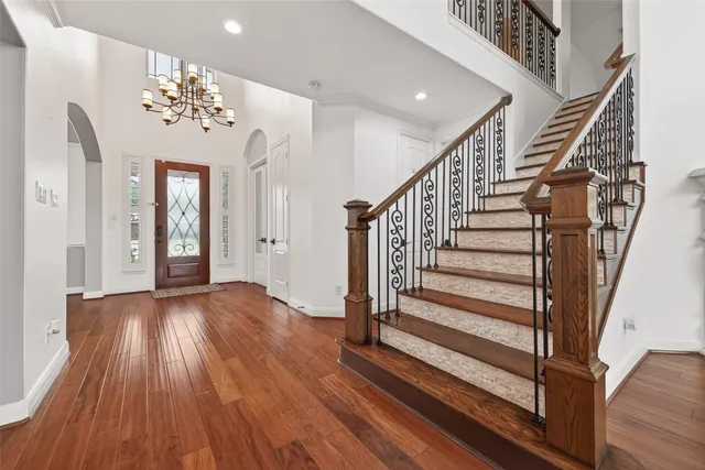 a view of a hallway with wooden floor and staircase