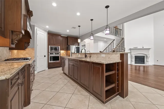 a kitchen with kitchen island granite countertop a stove and a sink