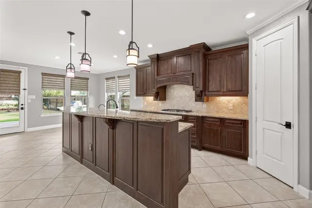 a kitchen with kitchen island granite countertop a sink counter top space appliances and cabinets