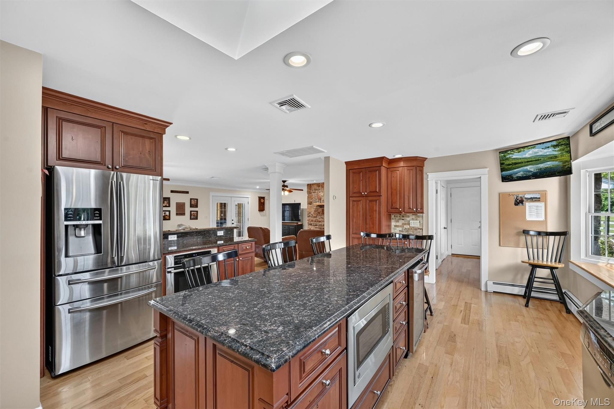 5 Hedges Road Warwick, NY 10990 - Photo 11 of 48 A spacious island anchors the kitchen, offering generous prep space, casual seating, granite countertops, stainless steel appliances, and thoughtful storage throughout.