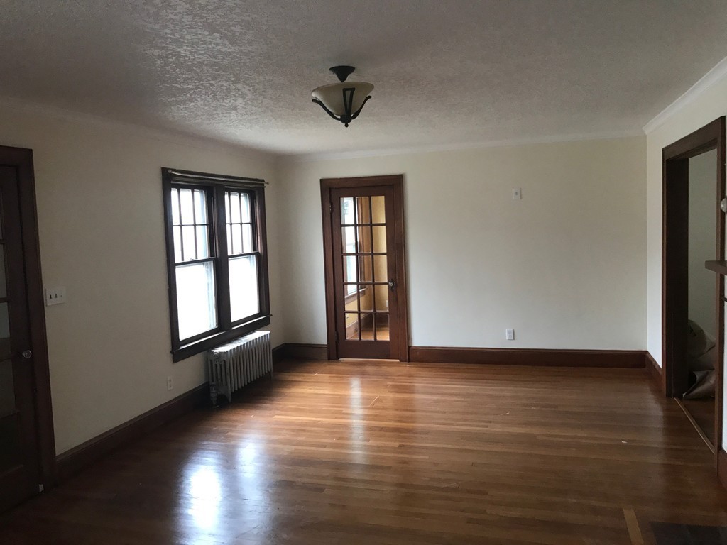 606 Alden Street Springfield, MA 01109 - Photo 4 of 22 an empty room with wooden floor and windows