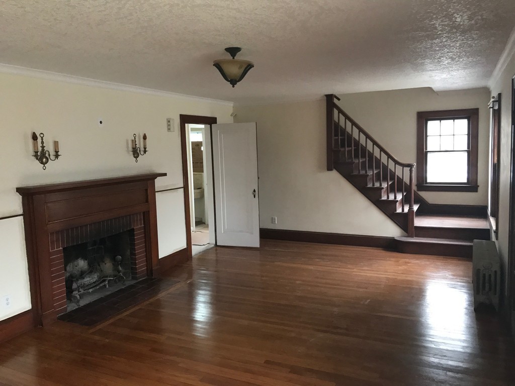 606 Alden Street Springfield, MA 01109 - Photo 5 of 22 a view of an empty room with wooden floor fireplace and a window