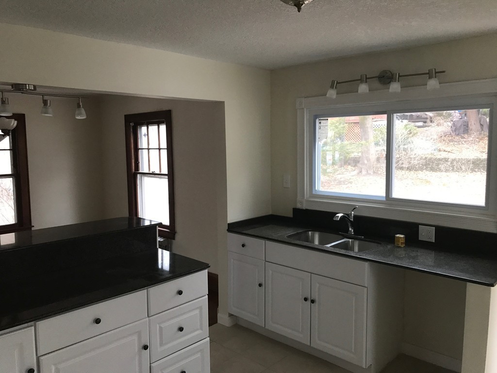 606 Alden Street Springfield, MA 01109 - Photo 10 of 22 a kitchen with granite countertop white cabinets white appliances and a large window
