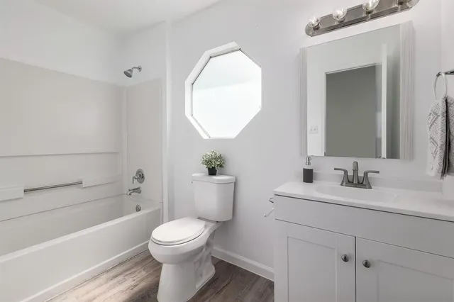 a bathroom with a toilet a sink a mirror and bathtub