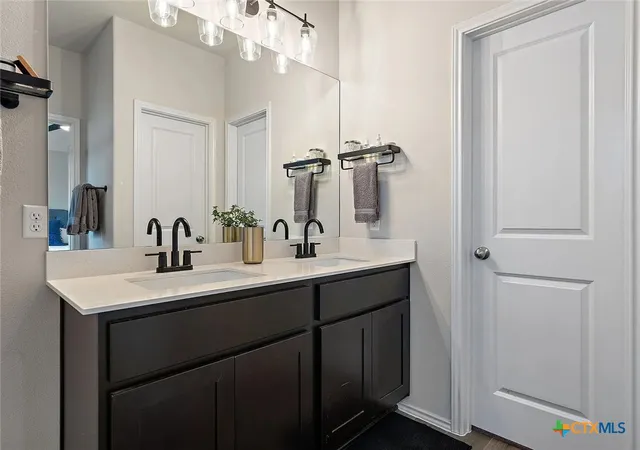 a bathroom with a sink double vanity and a mirror
