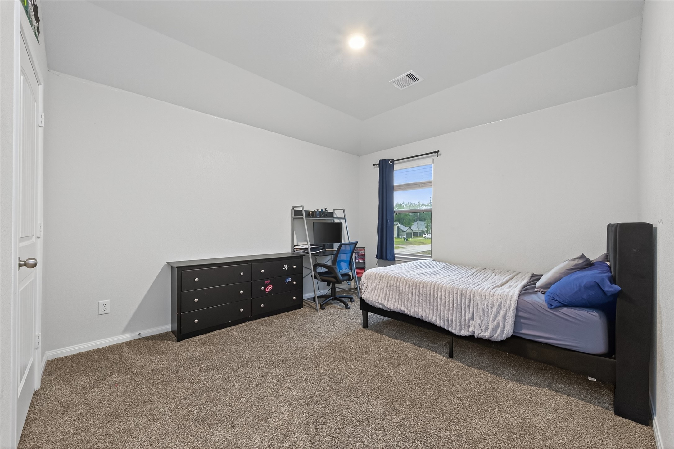 16601 Crosby Street Conroe, TX 77303 - Photo 32 of 50 Bright secondary bedroom with vaulted ceilings, plush carpeting, and a large window overlooking the neighborhood.