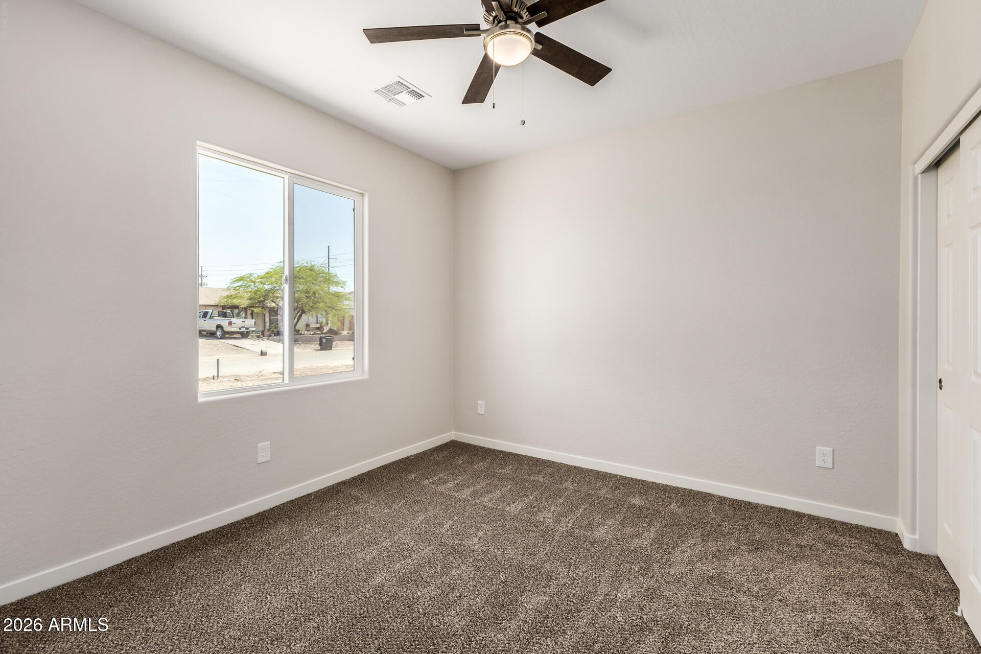 16022 South Naviska Road Arizona City, AZ 85123 - Photo 15 of 25 an empty room with a window and a fan