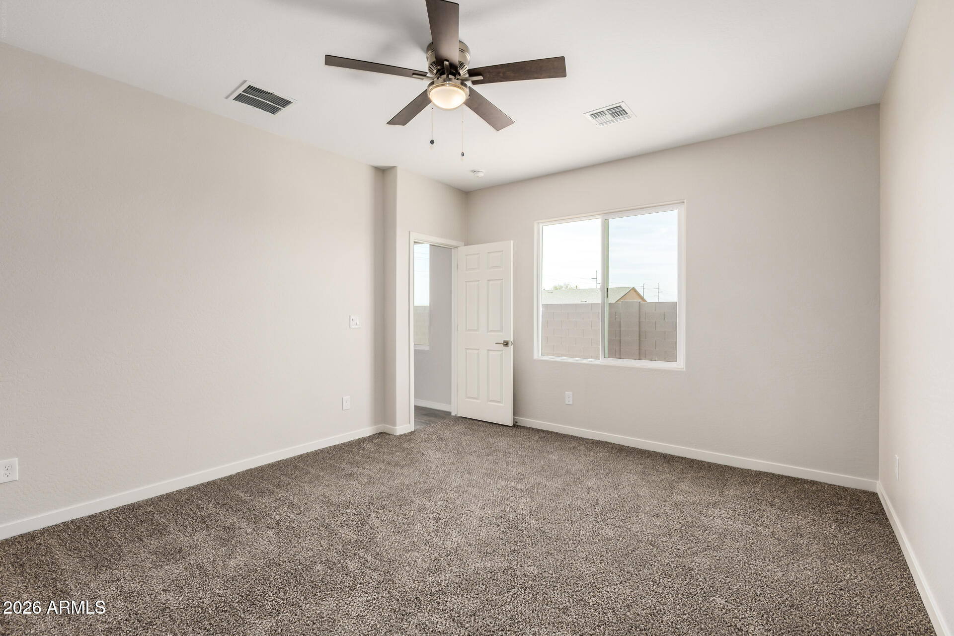 16022 South Naviska Road Arizona City, AZ 85123 - Photo 9 of 25 an empty room with windows and ceiling fan
