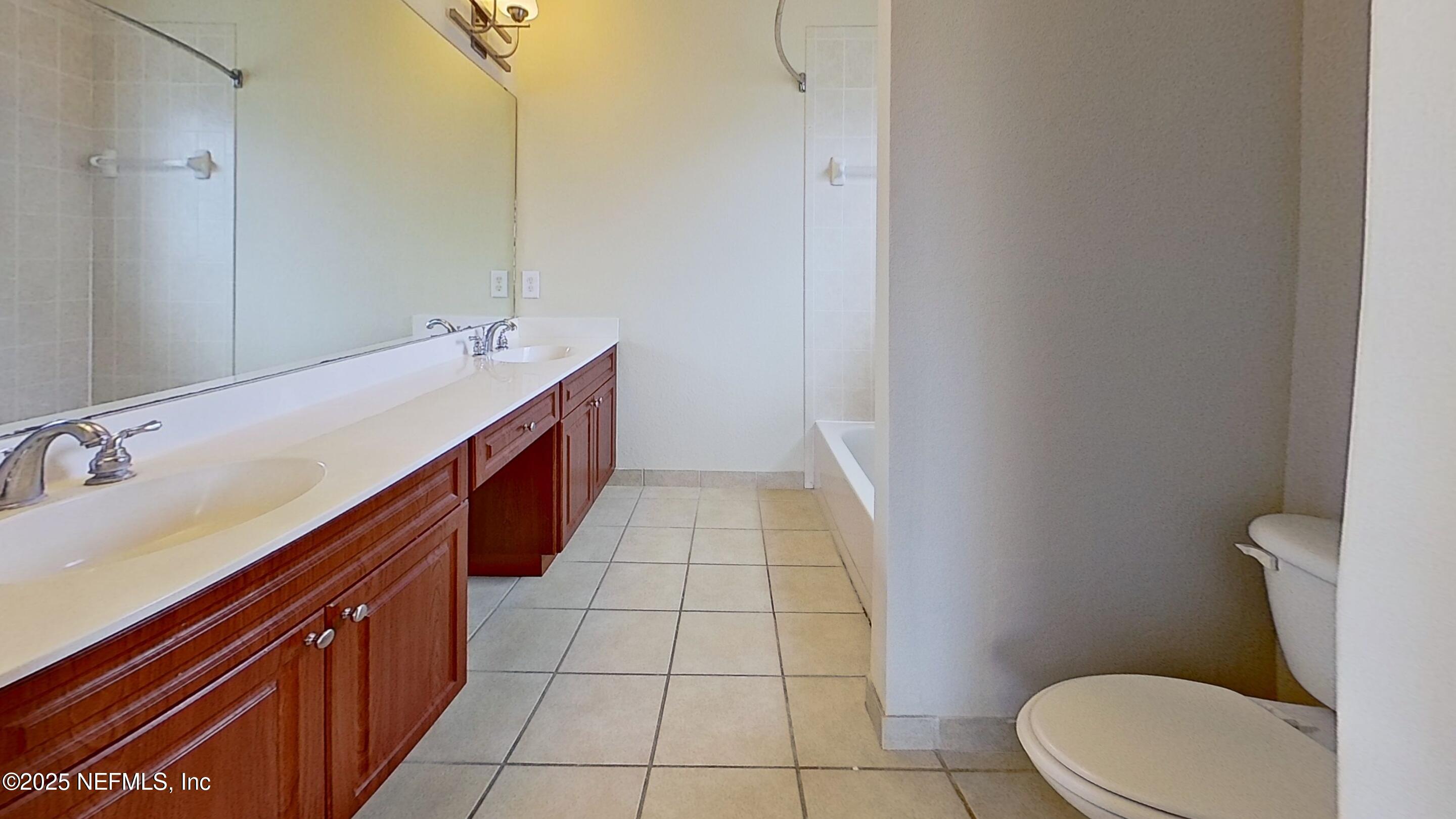 9745 Touchton Road, Unit 1421 Jacksonville, FL 32246 - Photo 12 of 22 a bathroom with a sink a toilet and mirror