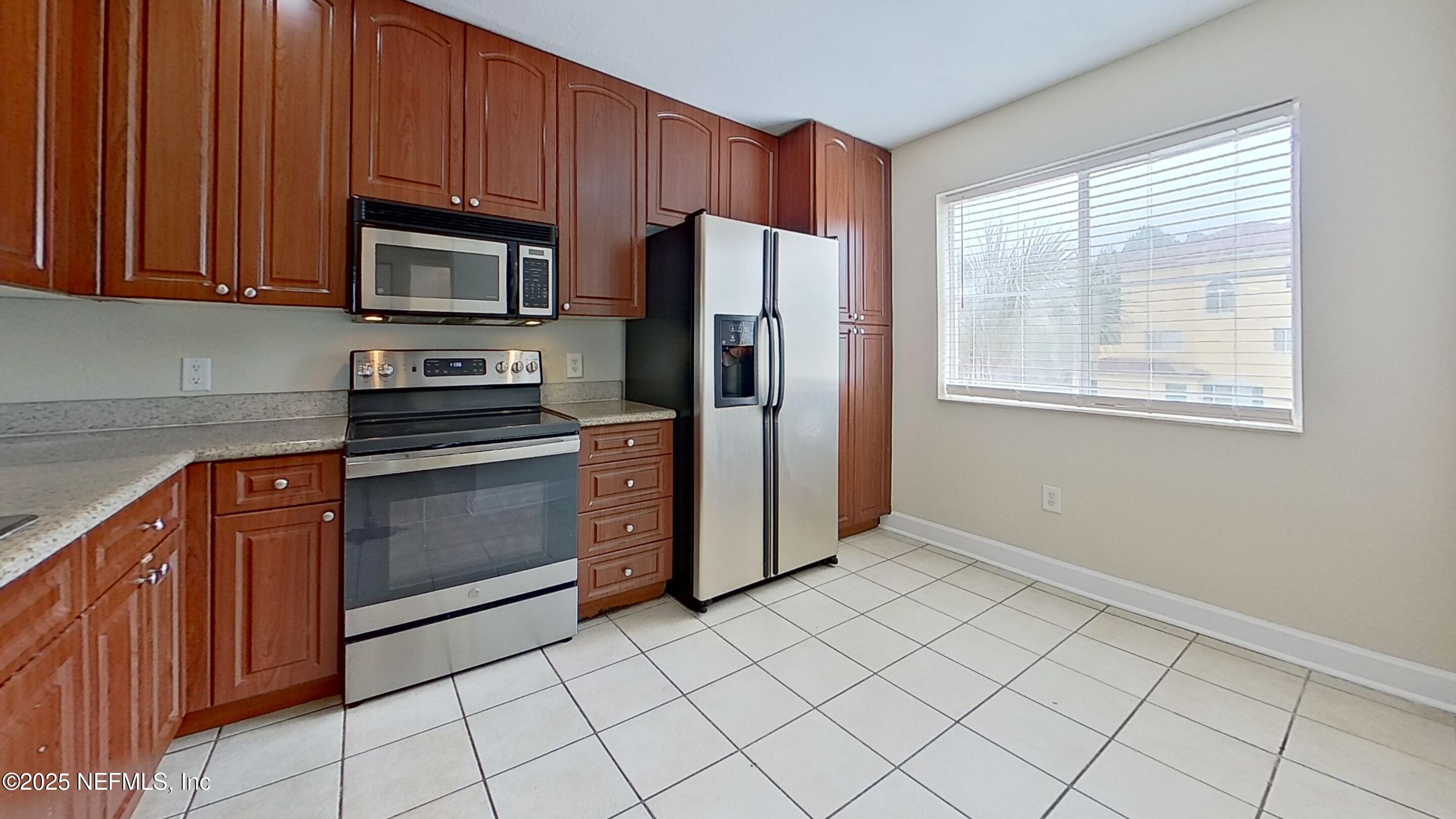 9745 Touchton Road, Unit 1421 Jacksonville, FL 32246 - Photo 7 of 22 a kitchen with granite countertop a refrigerator and a sink