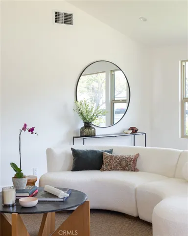 a living room with furniture and a mirror