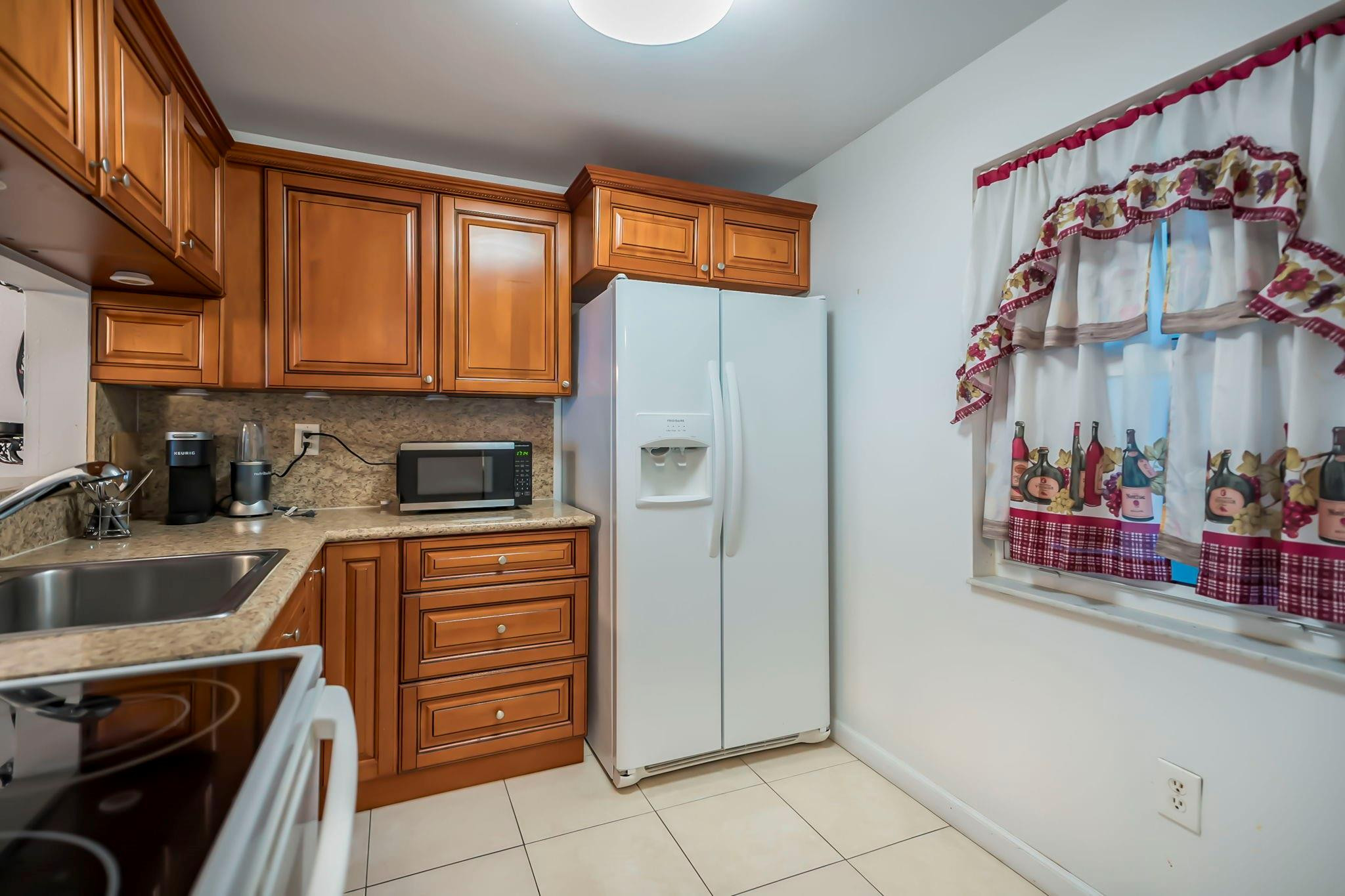 9401 Lime Bay Boulevard, Unit 209 Tamarac, FL 33321 - Photo 2 of 24 a kitchen with stainless steel appliances granite countertop a refrigerator and a stove top oven